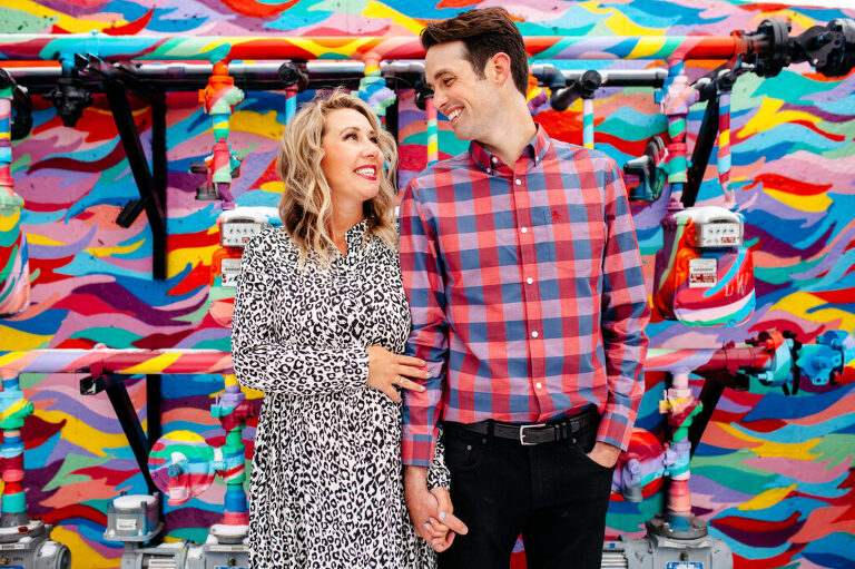 Pregnant woman and husband in Denver alley with colorful artwork