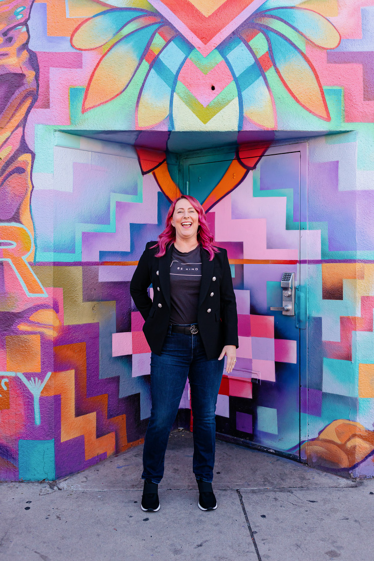 Client posing in RiNo with colorful artwork for Denver headshot session