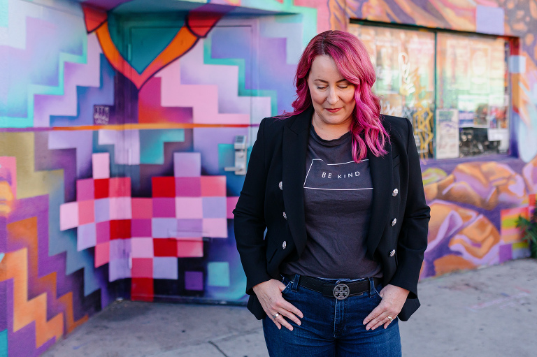 Client posing in RiNo with colorful artwork for Denver headshot session