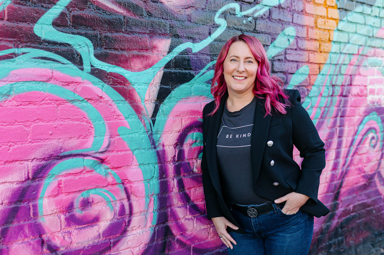 Client posing in RiNo with colorful artwork for Denver headshot session