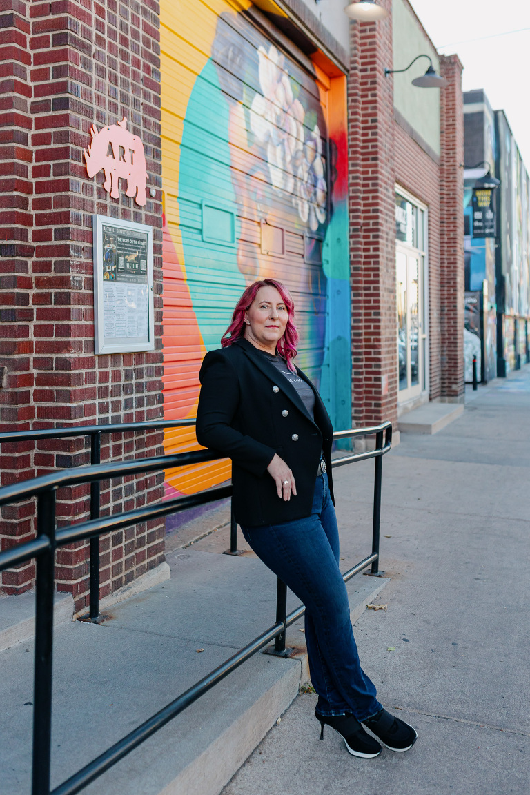 Client posing in RiNo with colorful artwork for Denver headshot session