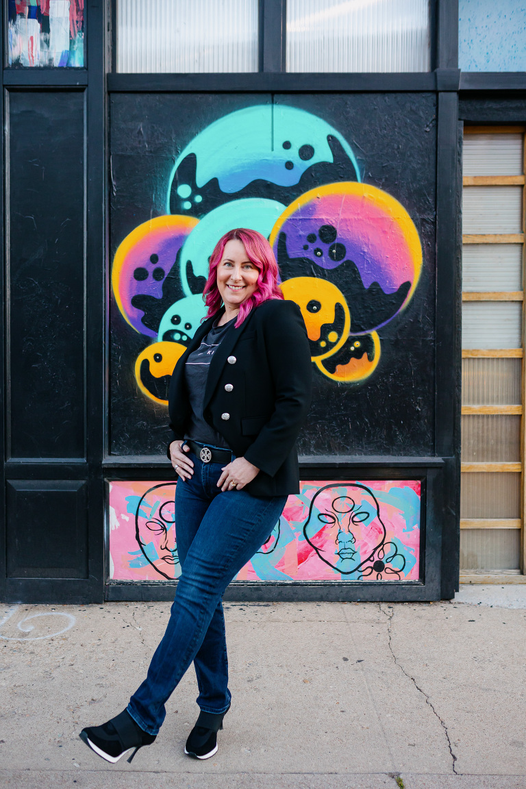 Client posing in RiNo with colorful artwork for Denver headshot session