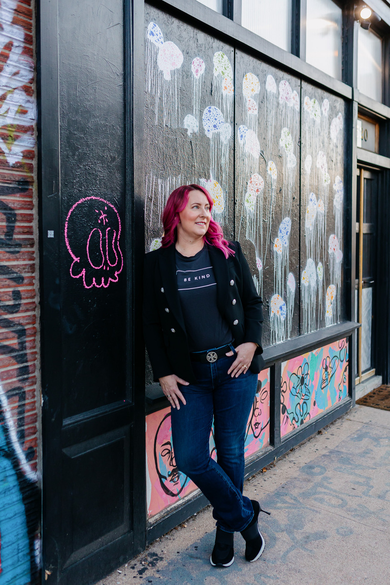 Client posing in RiNo with colorful artwork for Denver headshot session