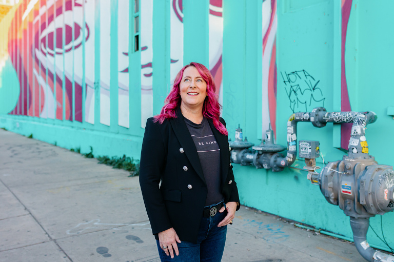 Client posing in RiNo with colorful artwork for Denver headshot session