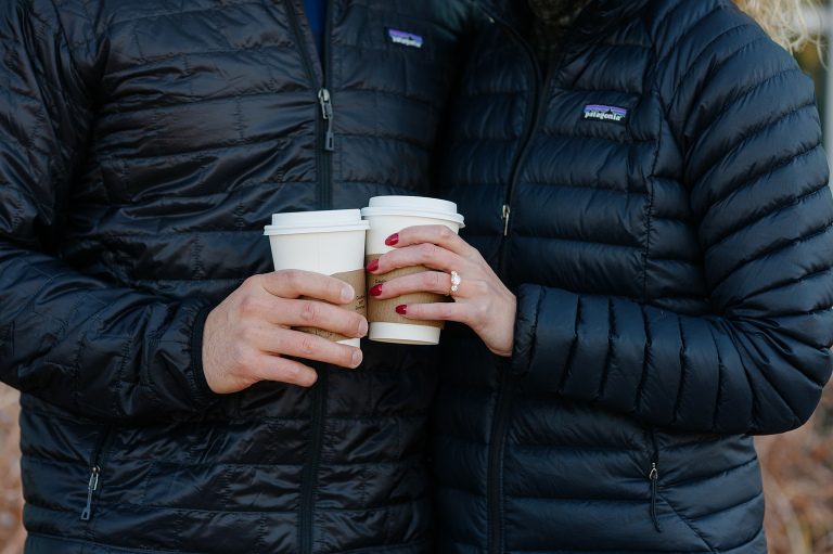 Engagement photos of couple holding coffees 