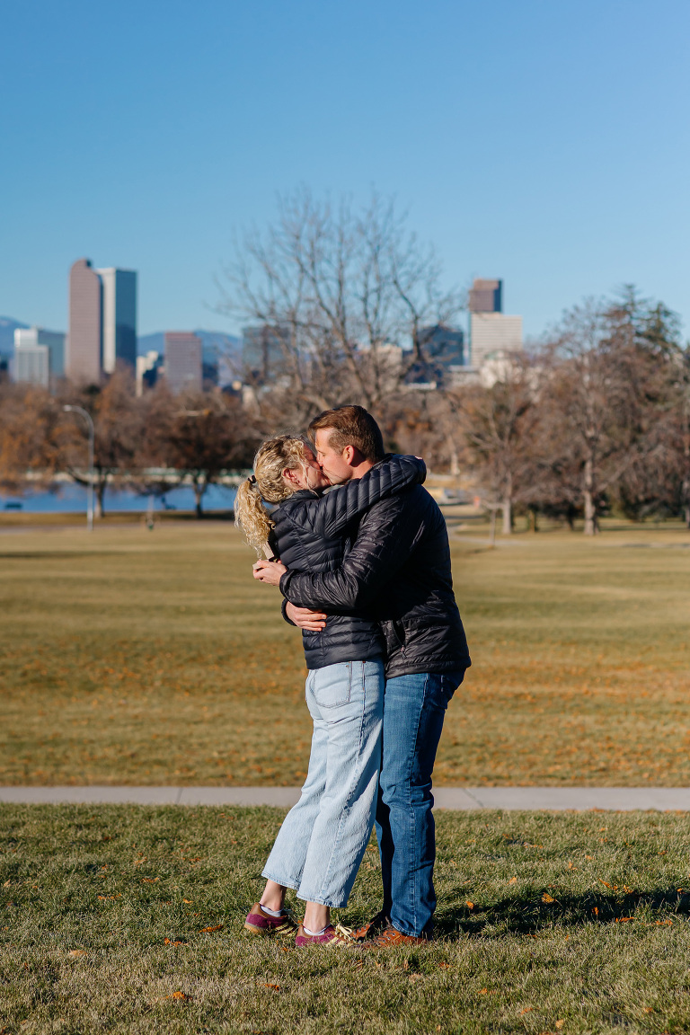 Proposal photos at City Park in Denver with city and mountains in the background