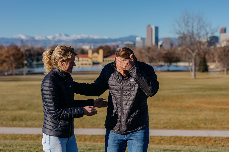 Proposal photos at City Park in Denver with city and mountains in the background