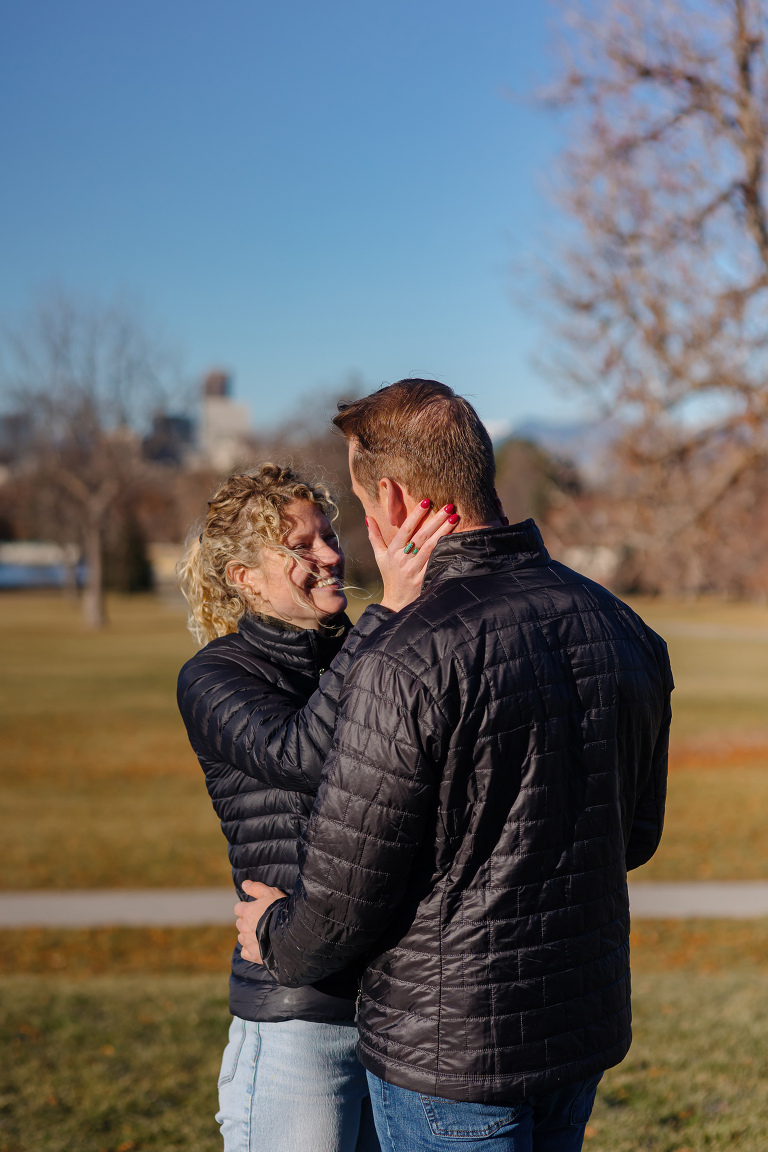 Proposal photos at City Park in Denver with city and mountains in the background