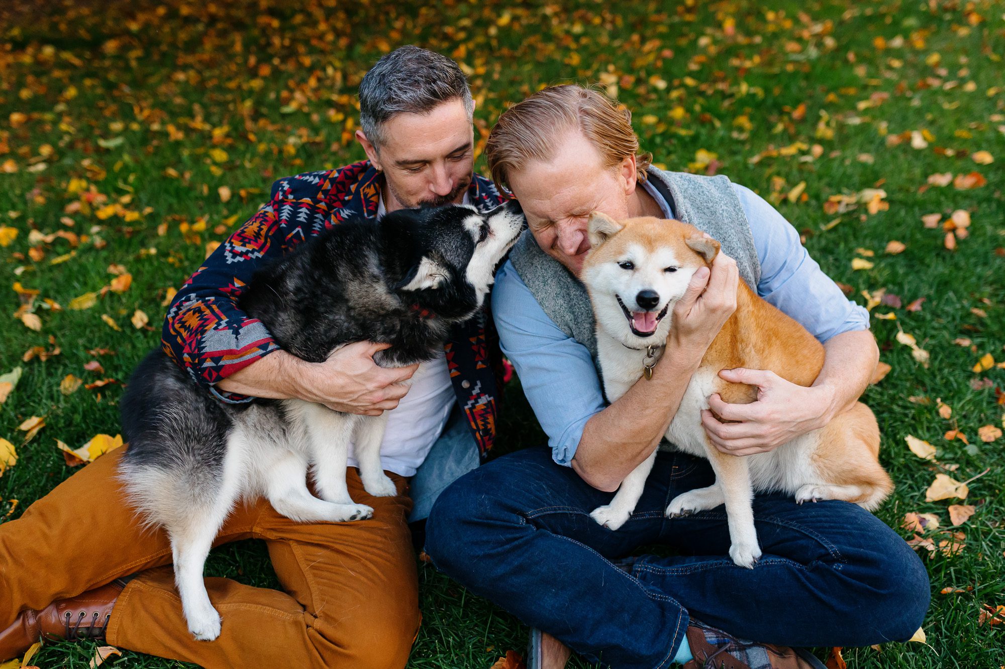 Family posing during Denver fall family session surrounded by golden leaves